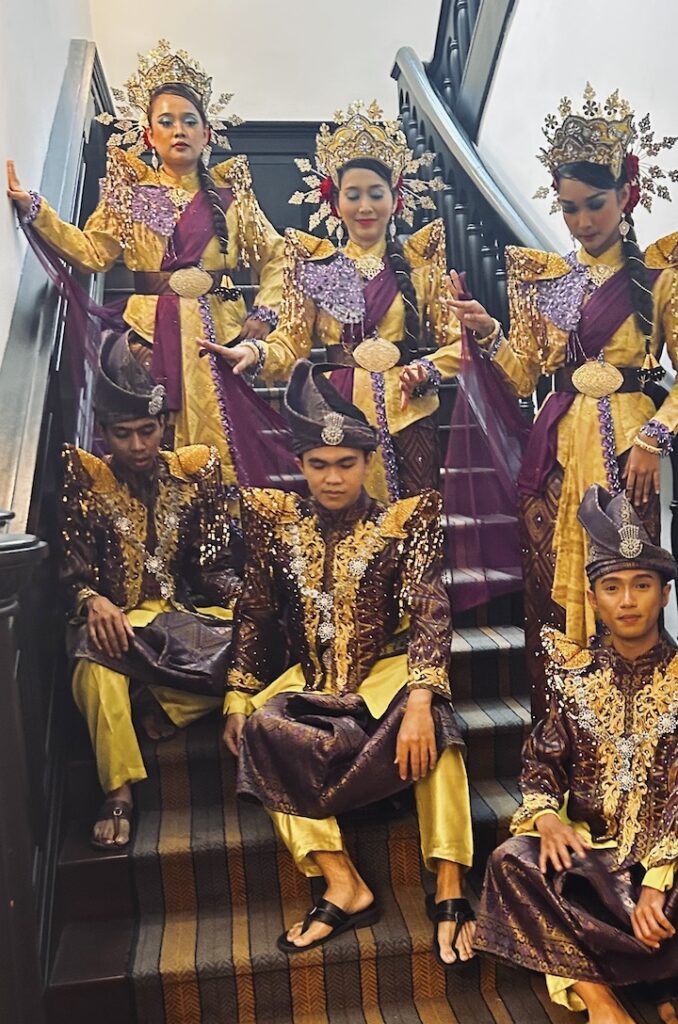 Malaysian dancers sitting on an E&O staircase 